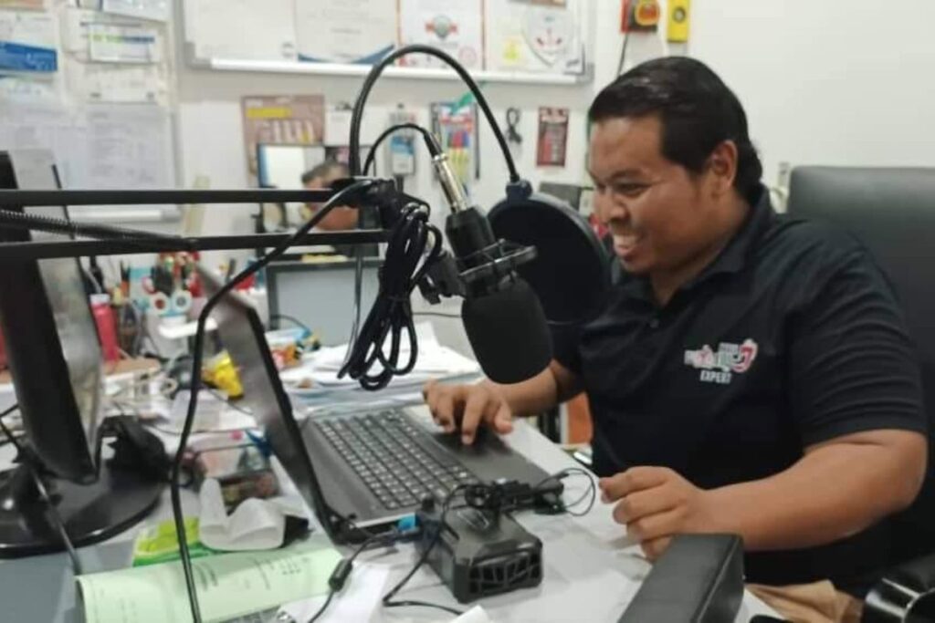 Trainer mengendalikan sesi latihan secara online menggunakan komputer dan mikrofon
